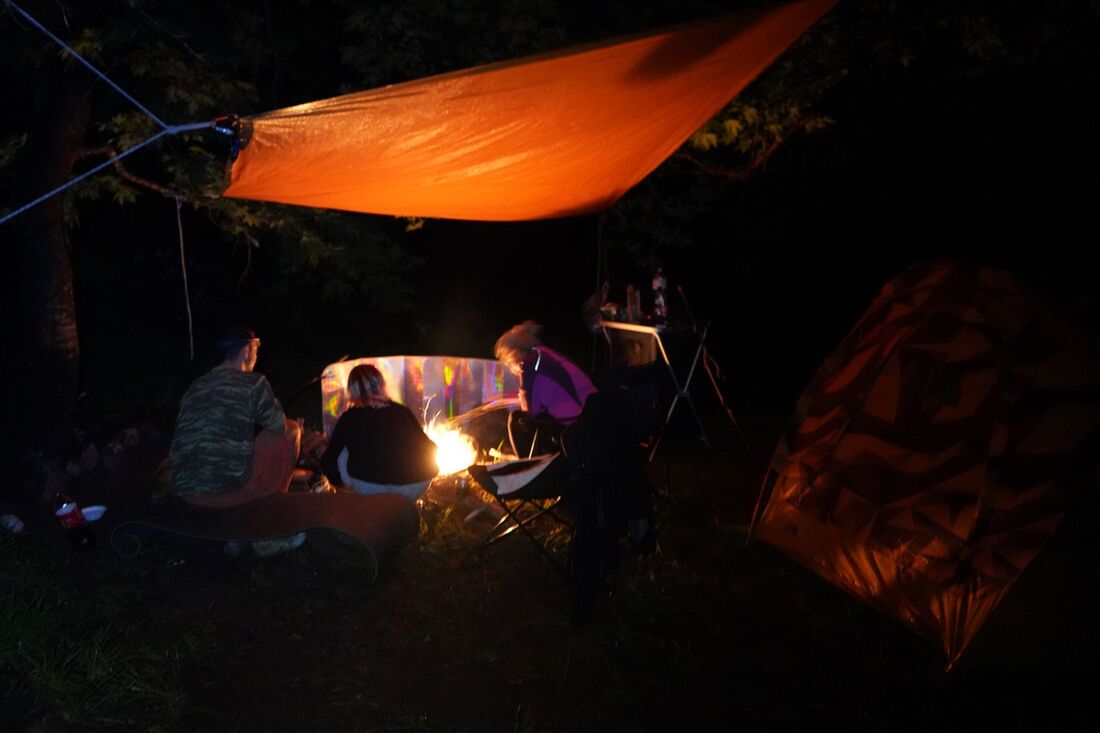 camp fire under a tent in the rain in the forest